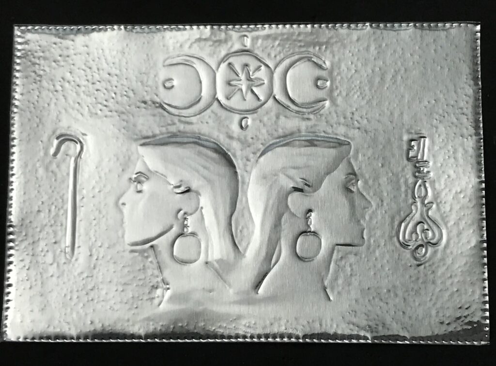 Embossing of two-headed goddess on metal.